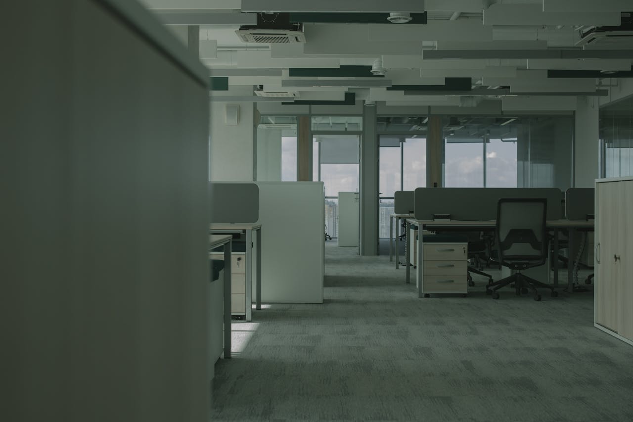 services-01 Spacious empty office featuring modern desks, chairs, and partitions.